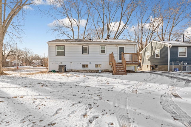 snow covered rear of property featuring a wooden deck and central air condition unit