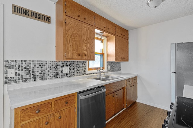 kitchen featuring appliances with stainless steel finishes, tasteful backsplash, dark hardwood / wood-style flooring, a textured ceiling, and sink