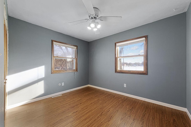 empty room with ceiling fan and hardwood / wood-style floors