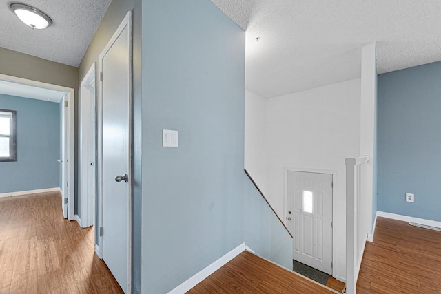 hall featuring a textured ceiling and hardwood / wood-style floors