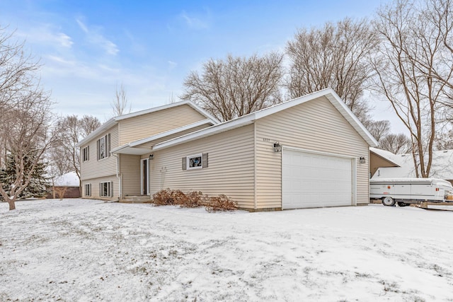 snow covered property with a garage