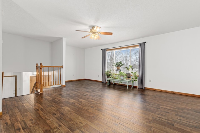 empty room with ceiling fan, dark hardwood / wood-style flooring, and a textured ceiling