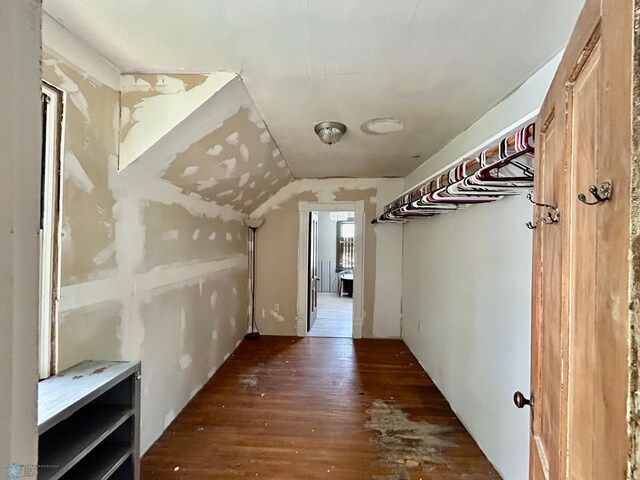 hallway with vaulted ceiling and dark hardwood / wood-style floors