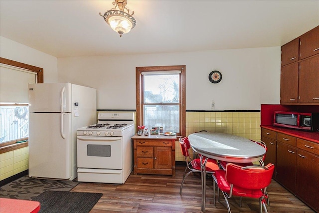 kitchen featuring tile walls, white appliances, dark brown cabinetry, and dark hardwood / wood-style floors