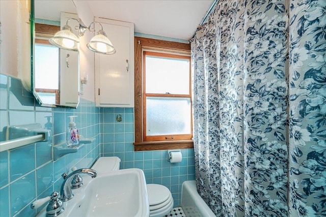 bathroom featuring toilet, sink, and tile walls