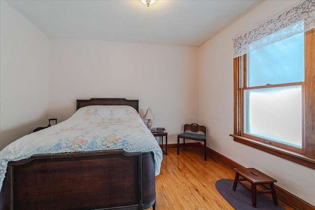 bedroom with multiple windows and light hardwood / wood-style flooring