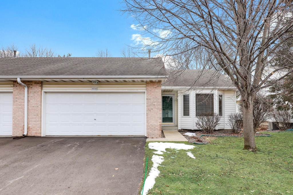 single story home with a garage and a front yard