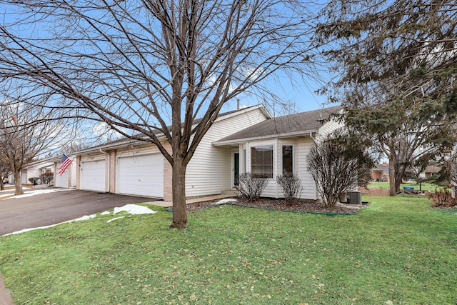 view of front of home with cooling unit, a front yard, and a garage