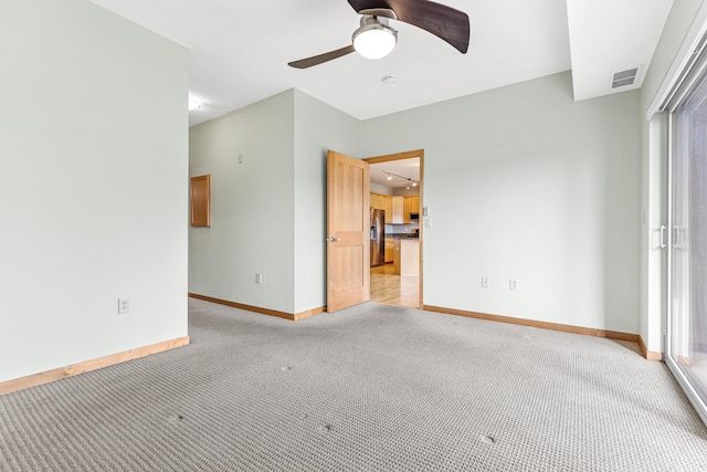 carpeted empty room featuring ceiling fan