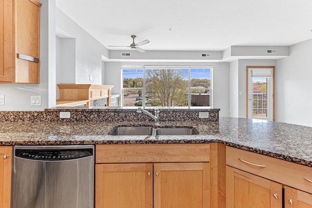 kitchen featuring stainless steel dishwasher, ceiling fan, sink, and dark stone counters