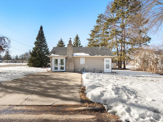 snow covered house with french doors