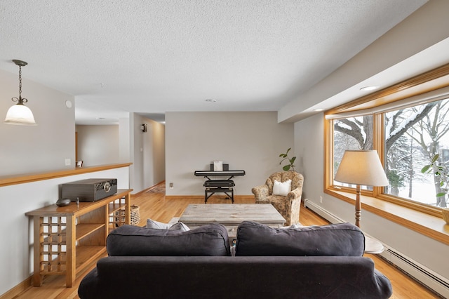 living room with light wood-type flooring, a textured ceiling, and a baseboard heating unit