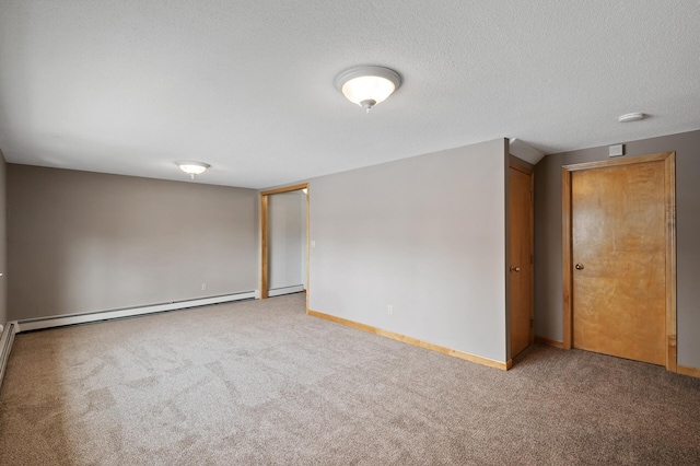 carpeted spare room with a baseboard radiator and a textured ceiling