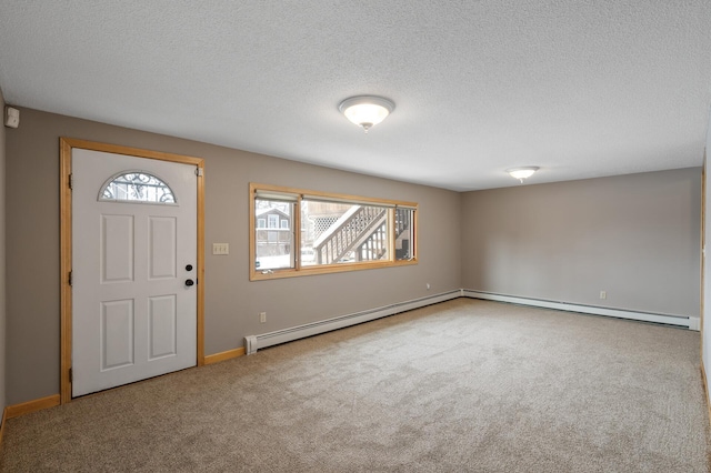 foyer with carpet floors, a textured ceiling, and a baseboard heating unit