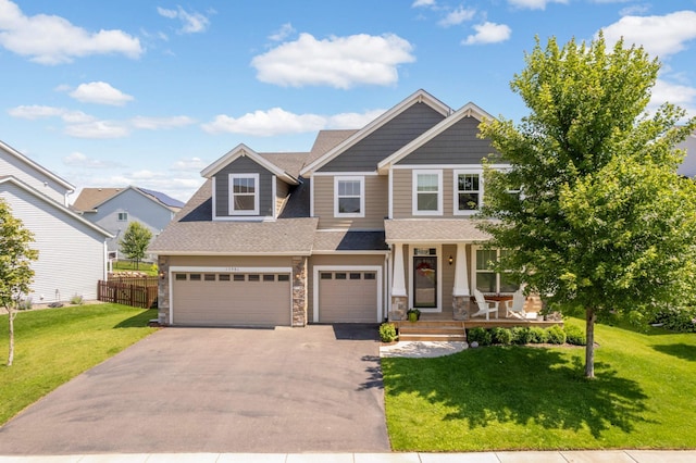 craftsman house featuring a porch, a garage, and a front lawn