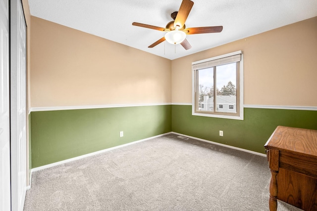 spare room with carpet floors and ceiling fan