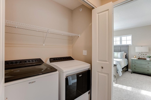 laundry room with washing machine and dryer and carpet