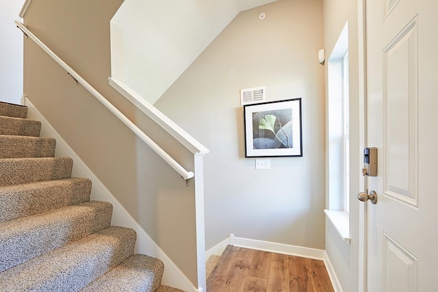 staircase with hardwood / wood-style floors