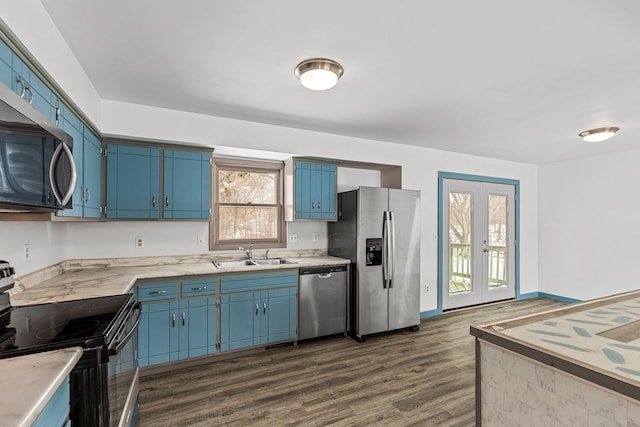 kitchen with stainless steel appliances, blue cabinets, sink, and a wealth of natural light