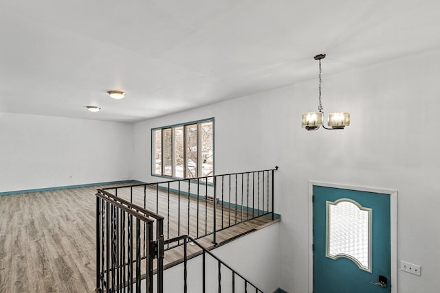 foyer with hardwood / wood-style floors and a notable chandelier