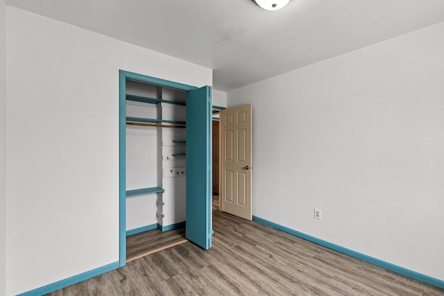 unfurnished bedroom featuring hardwood / wood-style floors and a closet