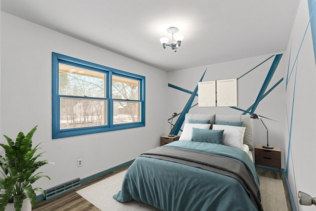 bedroom with dark wood-type flooring and a notable chandelier