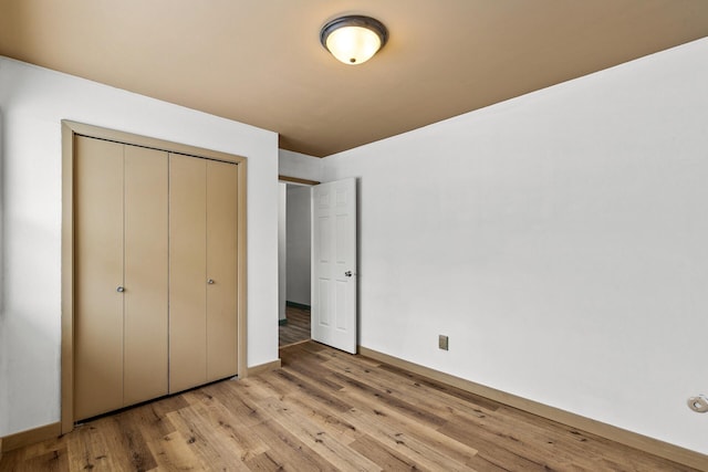 unfurnished bedroom featuring light hardwood / wood-style flooring and a closet