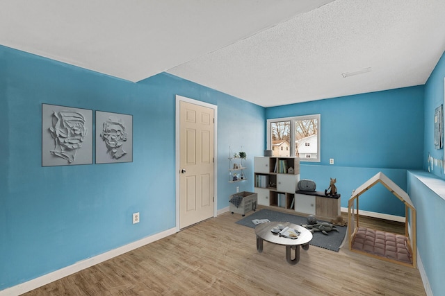 living area featuring wood-type flooring and a textured ceiling