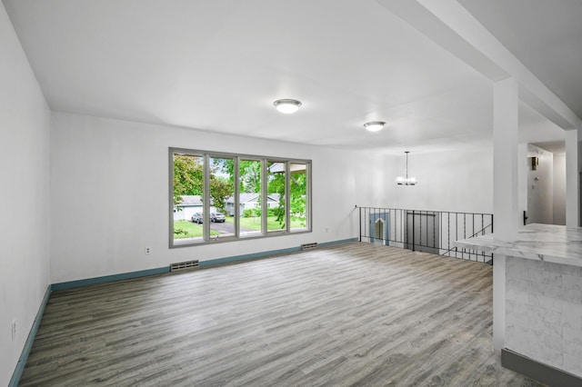1813 Stinson Blvd, New Brighton, MN 55112 - empty room featuring a chandelier, dark wood finished floors, and baseboards