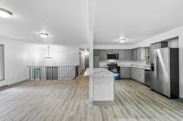 1813 Stinson Blvd, New Brighton, MN 55112 - kitchen featuring stainless steel appliances, gray cabinetry, light countertops, light wood finished floors, and a chandelier