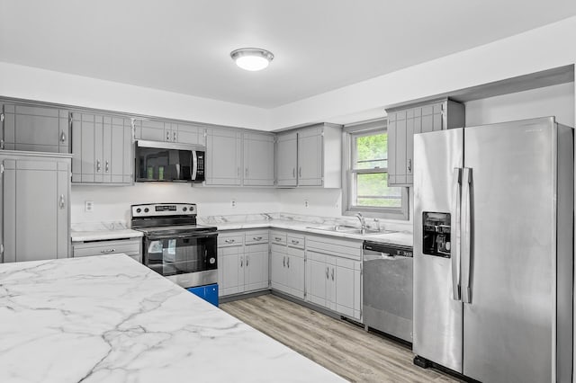 1813 Stinson Blvd, New Brighton, MN 55112 - kitchen featuring appliances with stainless steel finishes, gray cabinetry, a sink, and light wood-type flooring