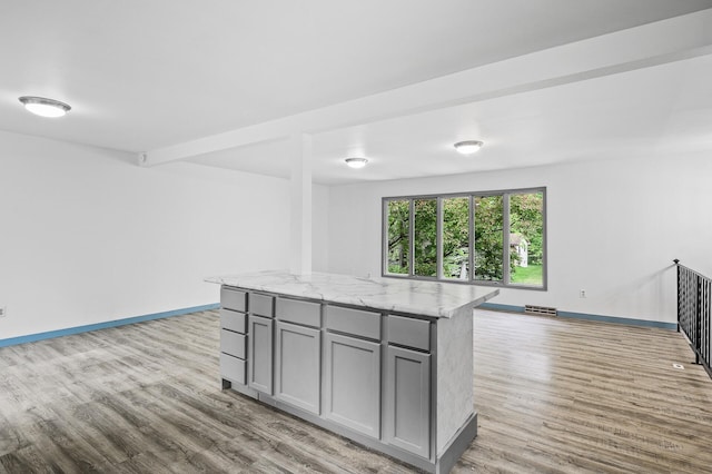 1813 Stinson Blvd, New Brighton, MN 55112 - kitchen featuring gray cabinetry, light wood-type flooring, baseboards, open floor plan, and light stone countertops