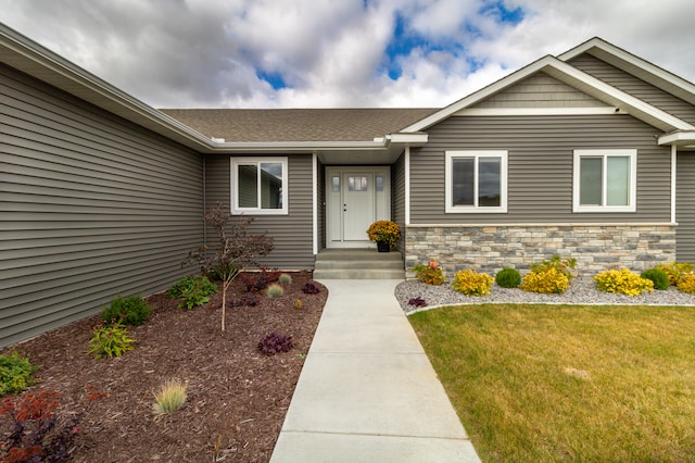 property entrance with a lawn