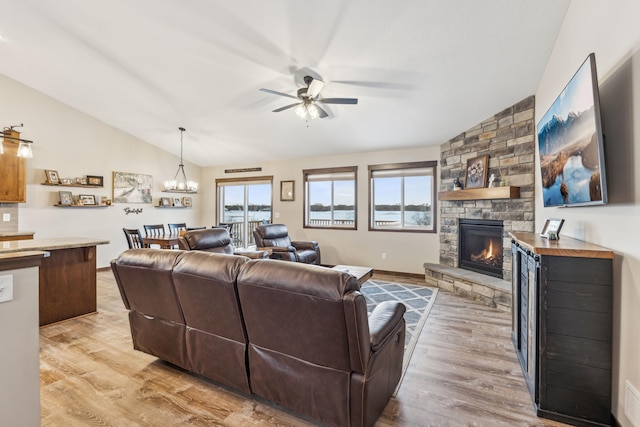 living room featuring lofted ceiling, light wood-type flooring, and a fireplace