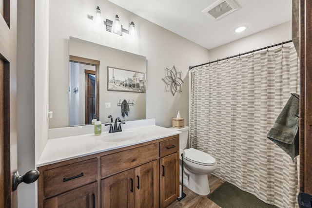 bathroom with hardwood / wood-style flooring, toilet, and vanity