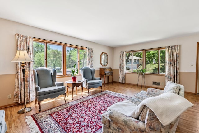 living room with healthy amount of natural light, wood finished floors, and baseboards