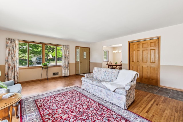living room with a chandelier, wood finished floors, and baseboards