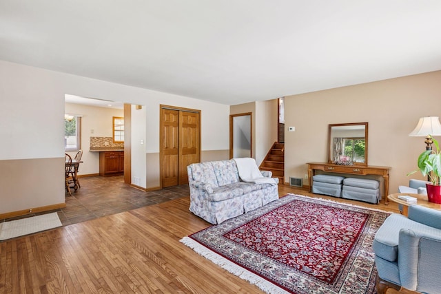 living room featuring stairway, healthy amount of natural light, wood finished floors, and baseboards