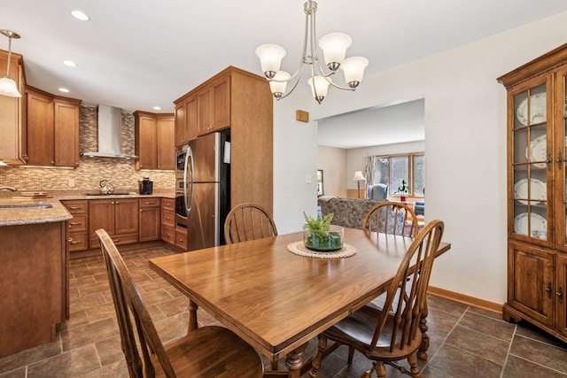dining room featuring a chandelier, dark stone finish floors, recessed lighting, and baseboards