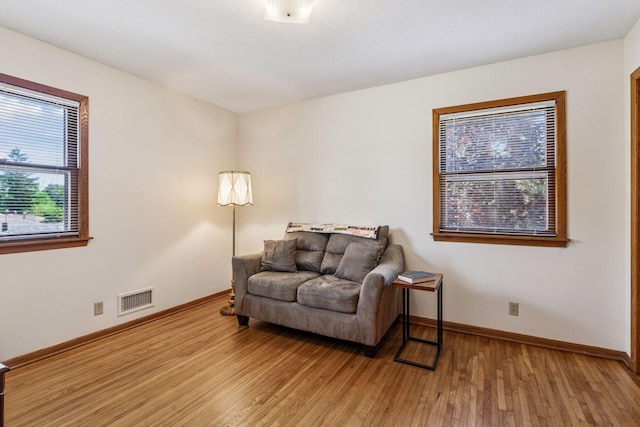 sitting room with baseboards and wood finished floors