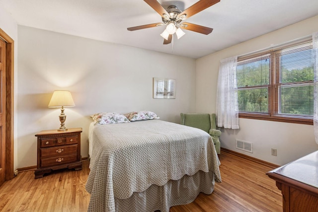 bedroom with light wood finished floors, baseboards, and a ceiling fan