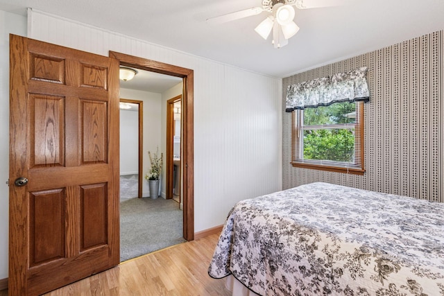 bedroom with light wood-style floors, ceiling fan, crown molding, and baseboards