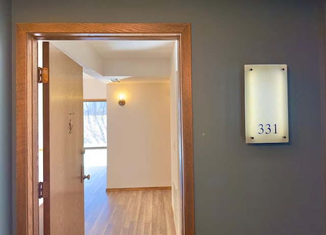 hallway with light hardwood / wood-style floors