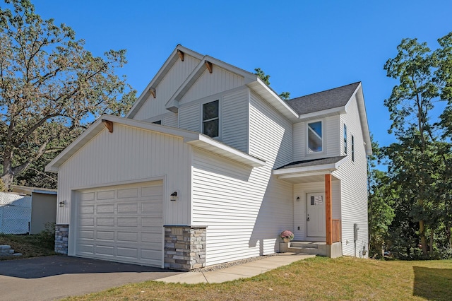 view of front of house featuring entry steps, aphalt driveway, roof with shingles, and an attached garage