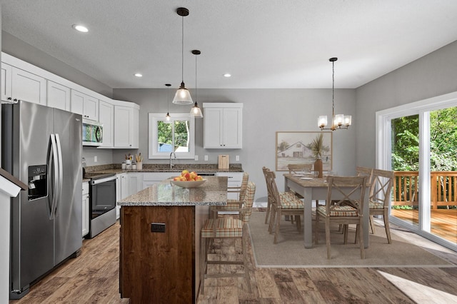 kitchen with appliances with stainless steel finishes, a kitchen island, and white cabinets