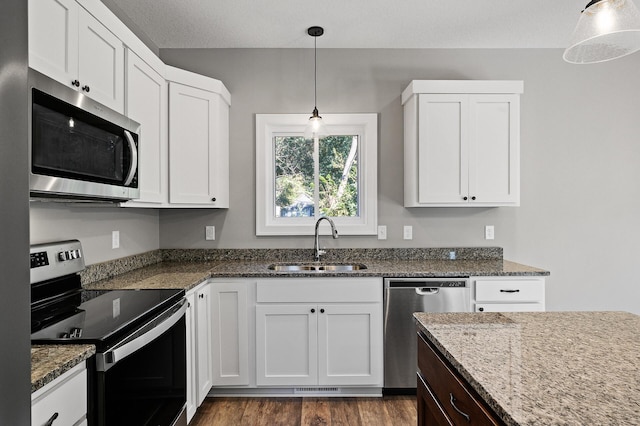 kitchen featuring stainless steel appliances, white cabinetry, and a sink