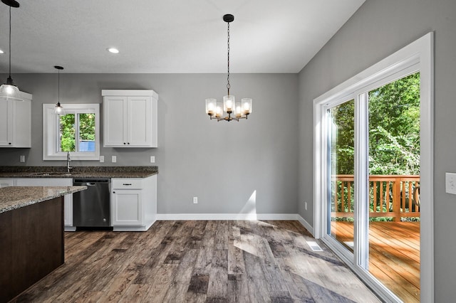 kitchen with dark wood-style floors, hanging light fixtures, stainless steel dishwasher, white cabinets, and a sink