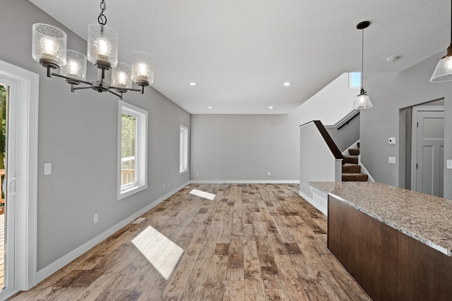 unfurnished dining area featuring stairs, wood finished floors, and a healthy amount of sunlight