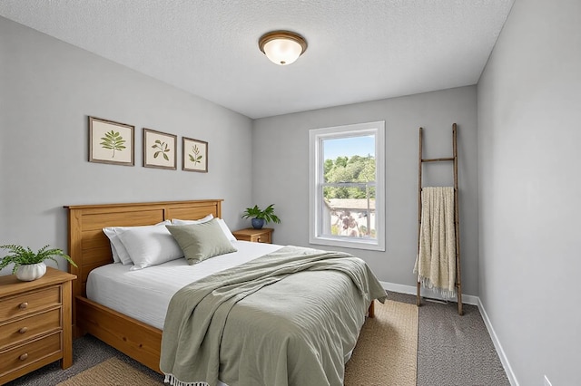 bedroom featuring a textured ceiling, dark carpet, and baseboards