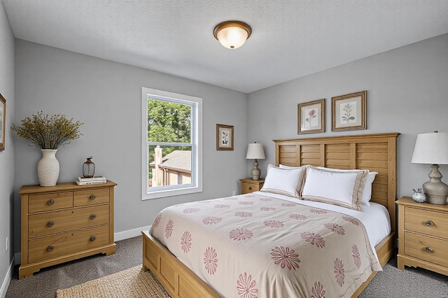 carpeted bedroom featuring a textured ceiling and baseboards